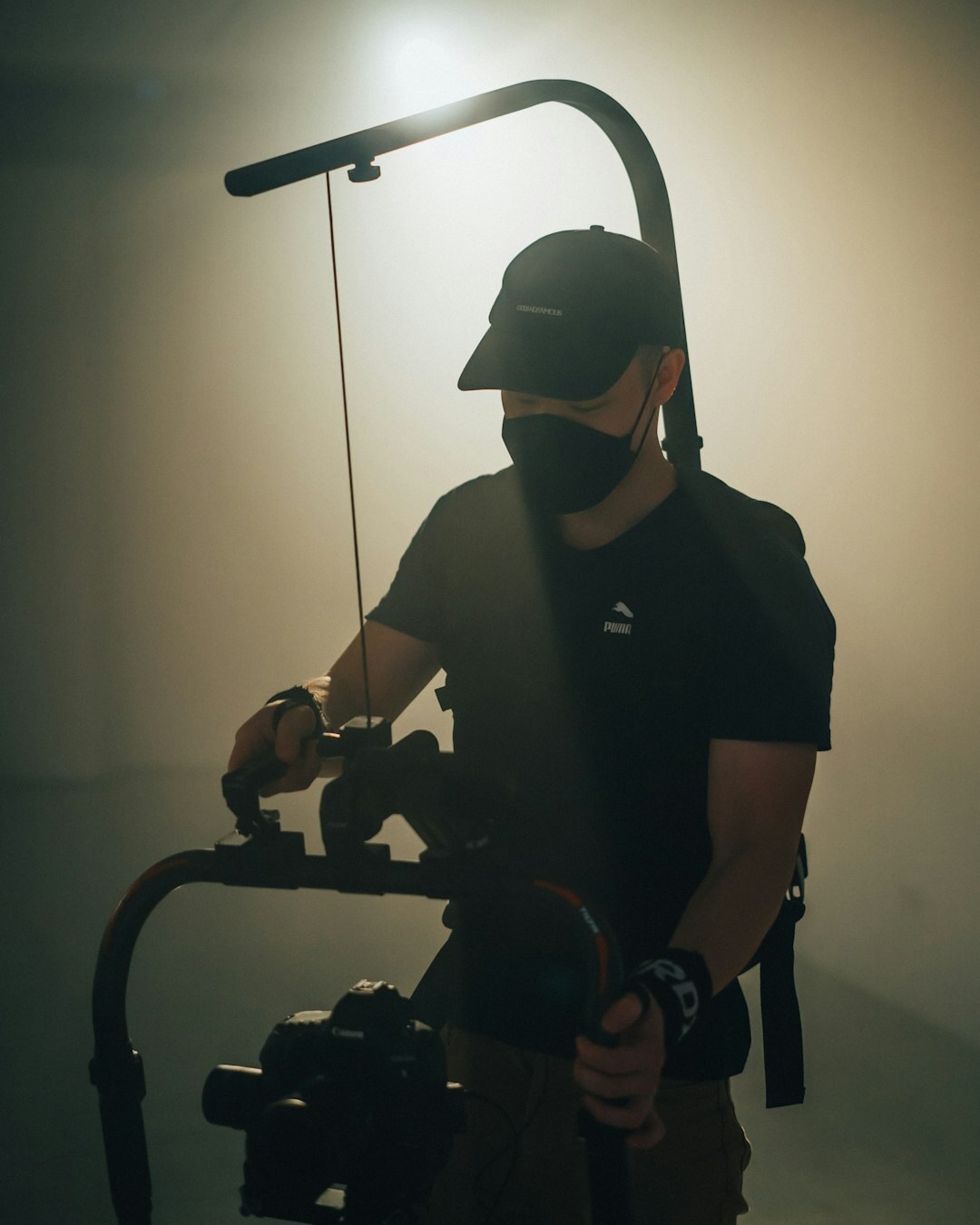 Camera operator adjusting studio lighting equipment