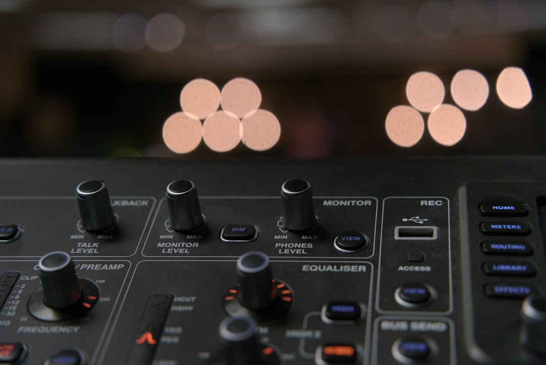 Audio mixing console with illuminated faders in a control room